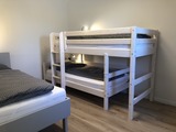Ferienhaus in Fehmarn OT Gammendorf - Feriendomizil SeeSand 2 - Schlafzimmer mit Etagenbett und Einzelbett Ferienhaus in Fehmarn OT Gammendorf - Feriendomizil SeeSand 2 - Schlafzimmer mit Etagenbett und Einzelbett