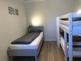 Ferienhaus in Fehmarn OT Gammendorf - Feriendomizil SeeSand 2 - Schlafzimmer mit Etagenbett und Einzelbett Ferienhaus in Fehmarn OT Gammendorf - Feriendomizil SeeSand 2 - Schlafzimmer mit Etagenbett und Einzelbett